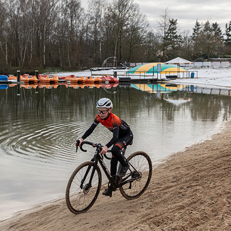 Jeugd veldrijder rijdt parcours langs waterplas - NK Veldrijden Jeugd 2026