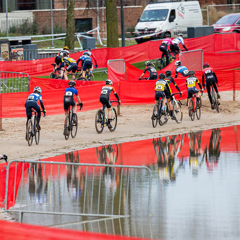 Jeugdveldrijders rijden parcours op zand langs water - NK Veldrijden 2026